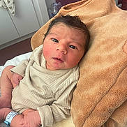 Gaya-Iliane participe au concours pour gagner de l'argent avec cette photo : newborn, baby, infant, hospital, blanket, wristband, clothing, face, person, skin, hand, bed, indoors, cozy, soft, cute, lying, looking, young, newborn_baby