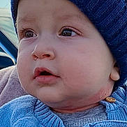 Ishmael is registered to the contest to win money with this photo: baby, child, face, hat, knitwear, sweater, blue, moon, star, closeup, outdoor, portrait, cute, warm_clothing, winter, expression, looking_away, skin, button, infant