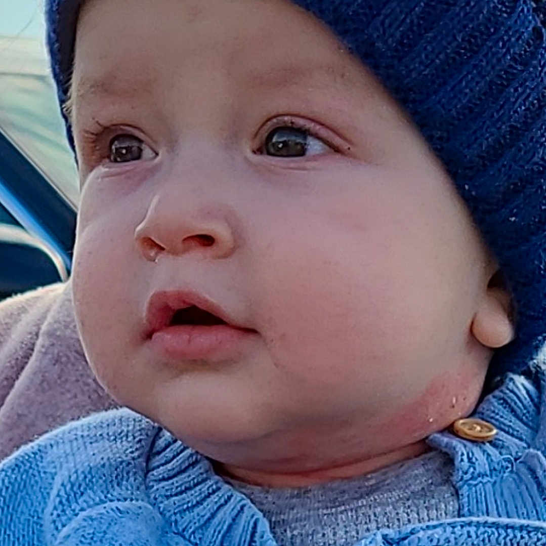 Ishmael is registered to the contest to win money with this photo: baby, blue, button, child, closeup, cute, expression, face, hat, infant, knitwear, looking_away, moon, outdoor, portrait, skin, star, sweater, warm_clothing, winter