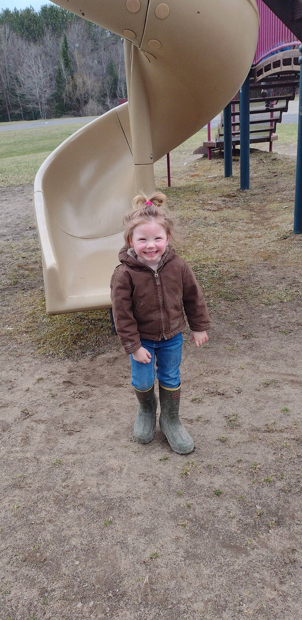 Emma is registered to the contest to win money with this photo: child, chute, fun, grass, jacket, jeans, joy, leisure, mammal, outdoor_play_equipment, person, plant, play, playground, playground_slide, recreation, road_surface, shade, smile, soil