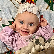 Nevaeh is registered to the contest to win money with this photo: baby, infant, smiling_baby, headband, bow, big_eyes, blanket, pajamas, cute, portrait, close_up, happy, cheeks, hands, tooth, girl, lying_down, soft_texture, holiday_blanket, cozy