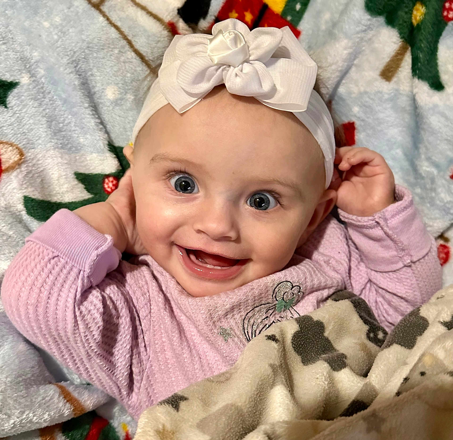 Nevaeh is registered to the contest to win money with this photo: baby, infant, smiling_baby, headband, bow, big_eyes, blanket, pajamas, cute, portrait, close_up, happy, cheeks, hands, tooth, girl, lying_down, soft_texture, holiday_blanket, cozy