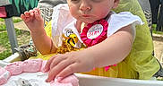Nevaeh is registered to the contest to win money with this photo: badge, birthday, cake, celebration, child, colorful, curious, face, flowers, food, garden, highchair, mural, outdoor, party, person, pink_frosting, smile, toddler, yellow_dress