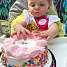 Nevaeh is registered to the contest to win money with this photo: badge, birthday, cake, celebration, child, clothing, colorful, face, flowers, frosting, highchair, mural, outdoor, party, person, pink, sprinkles, toddler, white, yellow