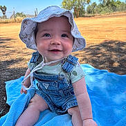 Wilder joined the competition — help win amazing prizes! baby, child, smiling, hat, sun_hat, denim_overalls, blue_blanket, outdoor, nature, sunny_day, grass, trees, happy, sitting, cute, infant, portrait, summer, playtime, skin
