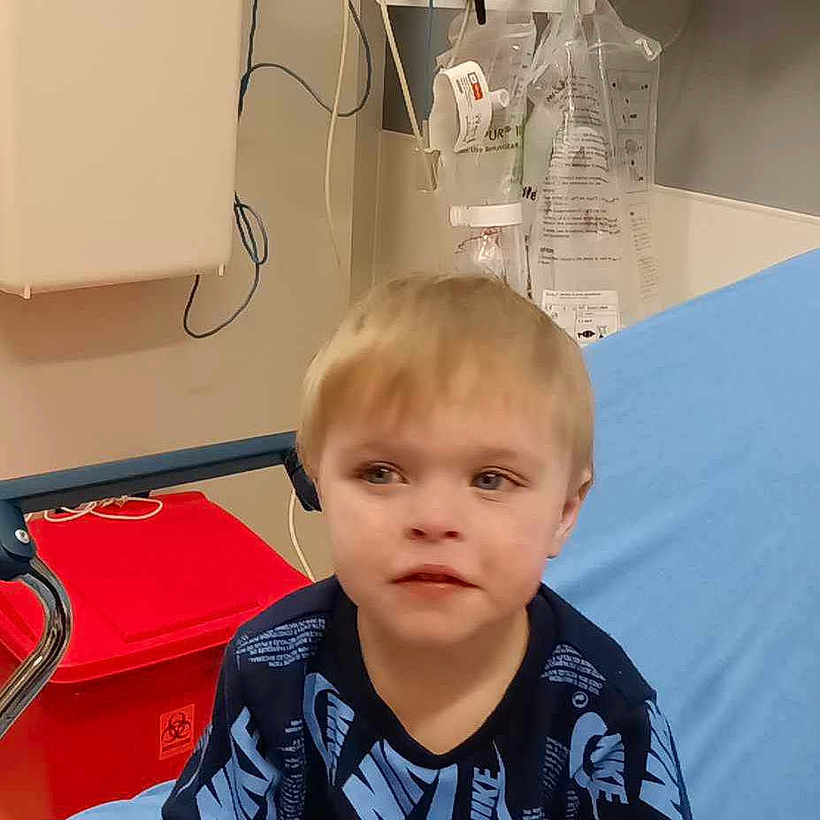 Mason is registered to the contest to win money with this photo: architecture, blanket, boy, building, child, clinic, clothing, cushion, face, head, homedecor, hosiery, hospital, male, person, photography, portrait, sitting, sleeve, sock