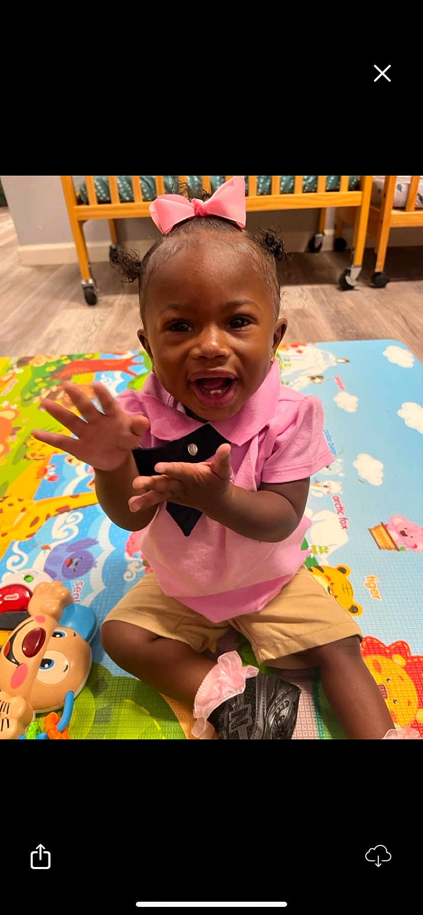 Kehlani joined the competition — help win amazing prizes! toddler, child, pink_bow, pink_shirt, clapping, play_mat, toy, smiling, happy, indoor, nursery, floor, shorts, black_shoes, baby, person, cute, young_child, playful, colorful