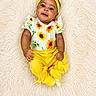 Dream joined the competition — help win amazing prizes! baby, child, clothing, cute, expression, flower, fluffy_rug, hand, happy, headband, indoors, infant, lying_down, pants, portrait, skin, smiling, socks, sunflower, yellow
