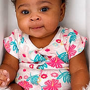 Dream is registered to the contest to win money with this photo: baby, blanket, child, closeup, clothing, curly_hair, cute, eyes, face, floral_pattern, fuzzy, happy, indoors, infant, onesie, portrait, sitting, skin, smile, soft_light