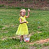 Lakelynn joined the competition — help win amazing prizes! child, girl, yellow_dress, easter_eggs, grass, outdoor, spring, basket, forest, nature, celebration, happy, holiday, play, person, greenery, sunlight, smile, toy, young