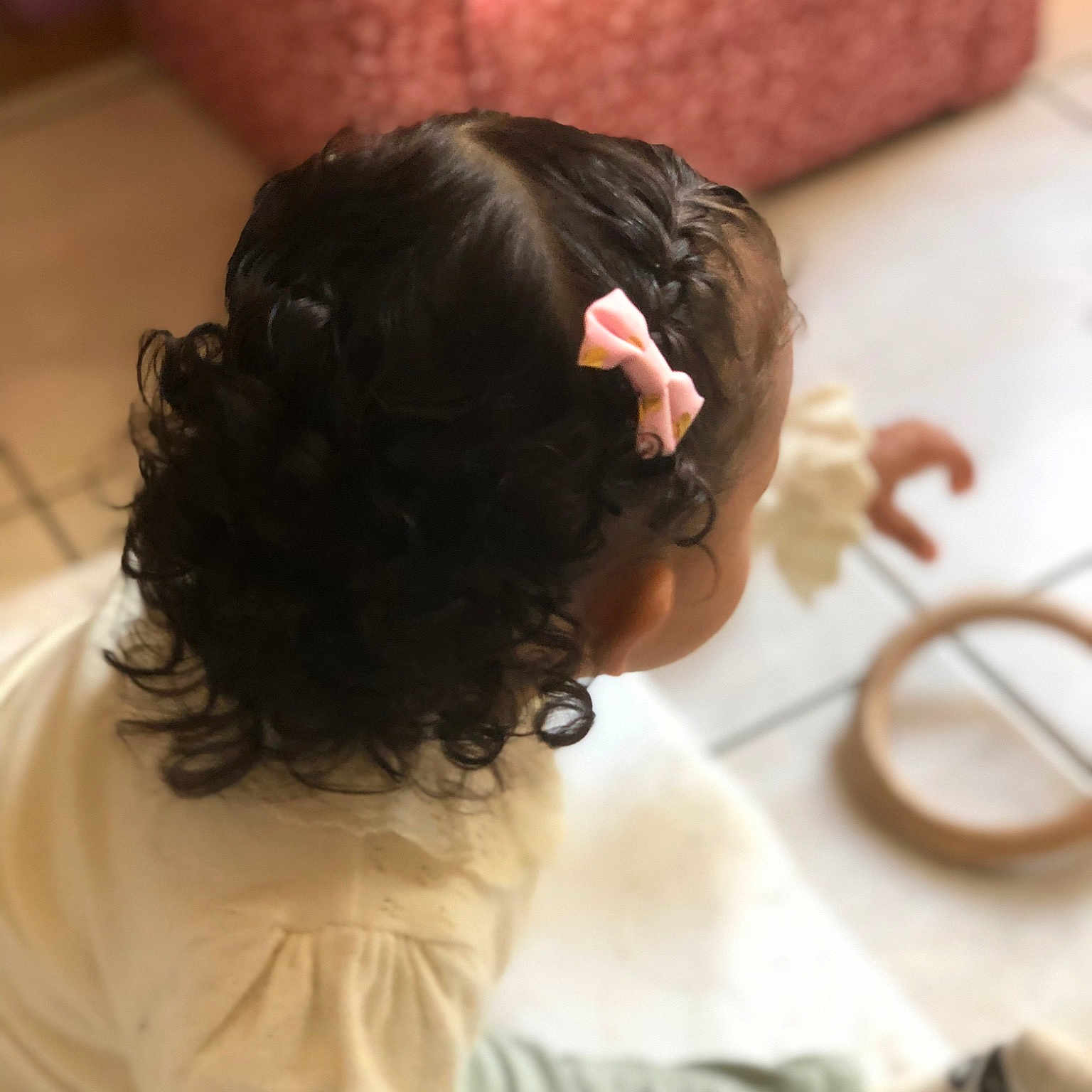 Naïssa participe au concours pour gagner de l'argent avec cette photo : black_hair, brown_hair, bun, child, comfort, ear, eyelash, eyewear, flooring, fun, hair_coloring, happy, neck, room, sitting, toddler, wood