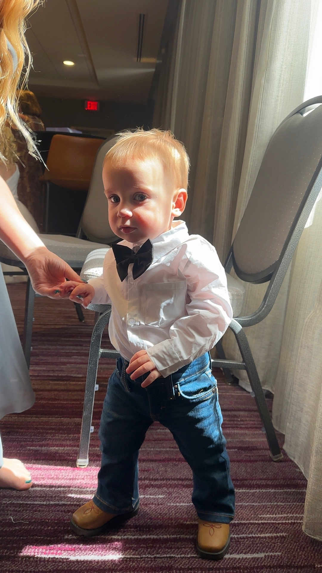 Ashton Tate joined the competition — help win amazing prizes! child, indoor, boy, standing, bow_tie, white_shirt, jeans, brown_shoes, carpet, hand_holding, curtains, chair, light, shadow, portrait, cute, casual_clothing, toddler, small_child, person