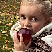 Ambre a rejoint le concours — aidez-le/la à gagner de superbes lots ! child, apple, autumn, leaves, outdoor, grass, jacket, hoodie, cozy, bite, food, snack, young, person, face, hand, brown_eyes, blonde_hair, nature, season
