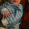 Walker is registered to the contest to win money with this photo: baby, infant, onesie, striped_clothing, smile, wink, hand, foot, face, sleepwear, child, person, patterned_background, fabric, cute, newborn, portrait, resting, cozy, indoors