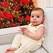 Ashur is registered to the contest to win money with this photo: baby, infant, child, knitwear, cream, couch, christmas_tree, red_baubles, lights, holiday, festive, indoors, portrait, sitting, cute, hands, feet, face, warm_lighting, decorations