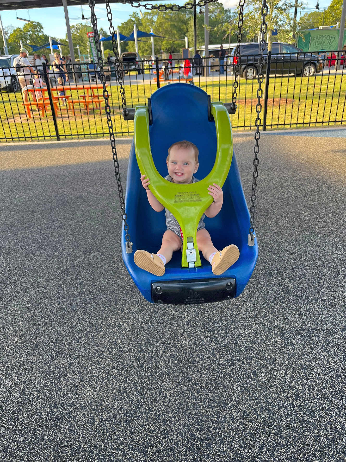 Everleigh is registered to the contest to win money with this photo: toddler, child, swing, playground, smile, outdoor, park, daylight, fence, people, grass, trees, shoes, clothing, play, fun, happy, baby, seat, chain