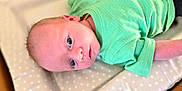 Tommy joined the competition — help win amazing prizes! baby, blue_eyes, changing_pad, child, closeup, curious, cute, expression, face, green_shirt, human, indoors, infant, lying_down, newborn, polka_dots, portrait, skin, soft_surface, toddler