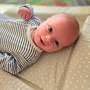 Tommy joined the competition — help win amazing prizes! baby, infant, smile, face, eyes, clothing, striped, onesie, padded_surface, polka_dot, lying_down, closeup, cute, portrait, child, young, soft_focus, indoor, baby_boy, happy