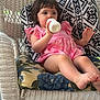 Scarlett joined the competition — help win amazing prizes! toddler, child, bottle, pink_dress, wicker_chair, cushion, patterned_cushion, indoor, sitting, relaxed, barefoot, short_hair, cute, baby, portrait, casual, resting, drink, home, comfort