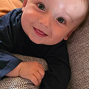 Leo a rejoint le concours — aidez-le/la à gagner de superbes lots ! baby, child, smiling, face, couch, hand, long_sleeve_shirt, happy, indoor, close_up, skin, person, infant, portrait, young_child, texture, fabric, relaxing, cute, comfortable