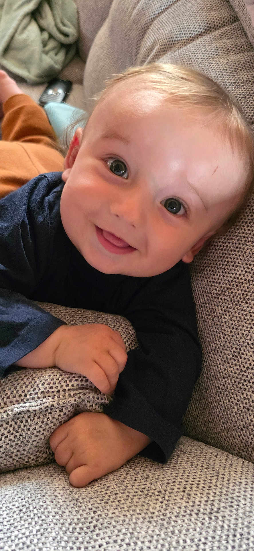 Leo a rejoint le concours — aidez-le/la à gagner de superbes lots ! baby, child, smiling, face, couch, hand, long_sleeve_shirt, happy, indoor, close_up, skin, person, infant, portrait, young_child, texture, fabric, relaxing, cute, comfortable