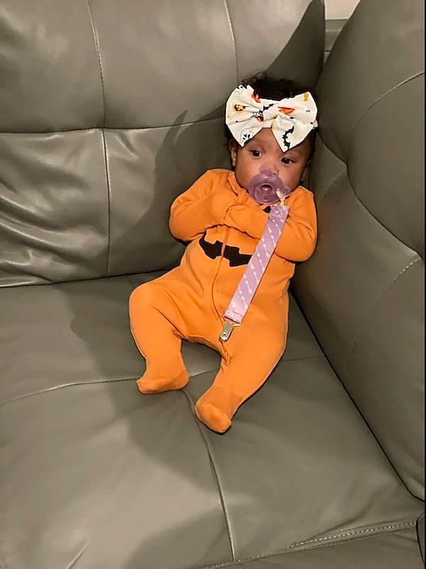 Jaide is registered to the contest to win money with this photo: animation, baby, baby_products, baby_toddler_clothing, bag, calabaza, car_seat, chair, comfort, couch, flooring, headwear, linens, orange, person, plush, room, sitting, stuffed_toy, toddler