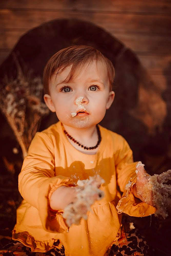 Maisy is registered to the contest to win money with this photo: baby, baby_toddler_clothing, cheek, child, dress, eye, flash_photography, fun, grass, happy, iris, nose, person, portrait_photography, sitting, skin, sleeve, smile, toddler, tree