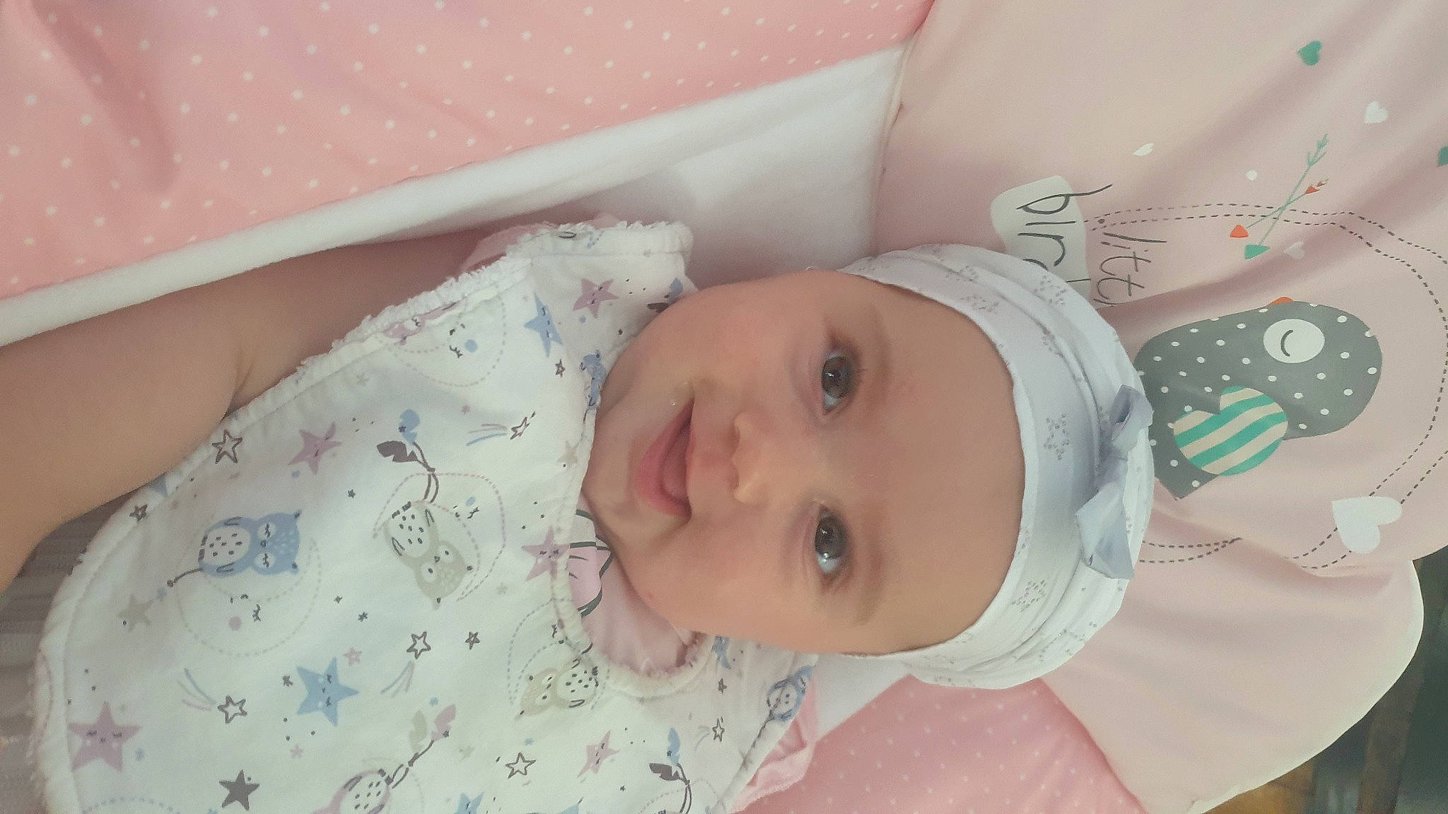 Elina participe au concours pour gagner de l'argent avec cette photo : baby, baby_products, baby_safety, baby_toddler_clothing, child, comfort, eyelash, happy, hat, headgear, headwear, iris, linens, pattern, person, pink, room, skin, sleeve, smile
