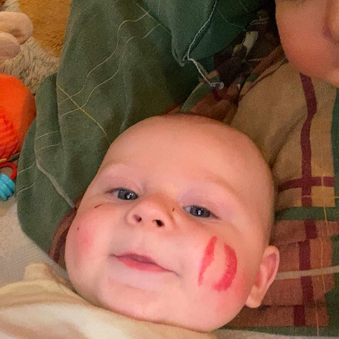 Kezyo a rejoint le concours — aidez-le/la à gagner de superbes lots ! adult, affection, baby, blanket, casual, cheek, child, closeup, cozy, expression, face, family, indoor, kiss_mark, person, pillow, resting, skin, smile, young_child