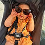 Rose a rejoint le concours — aidez-le/la à gagner de superbes lots ! baby, child, sunglasses, stroller, orange_clothing, romper, seatbelt, sitting, sunlight, hand, face, infant, cute, baby_toy, black_strap, outdoor, person, closeup, head, summer