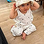 toddler, child, baby, indoor, floor, wooden_floor, hat, white_clothing, polka_dots, sitting, cute, curious, person, infant, young_child, headwear, barefoot, casual, home, portrait