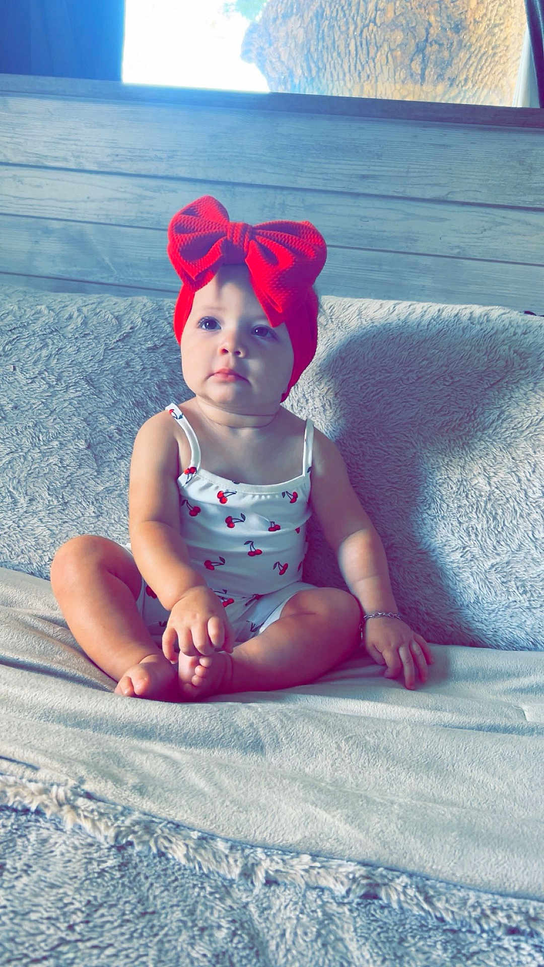 Autumn joined the competition — help win amazing prizes! baby, child, red_bow, headband, cherry_print, white_outfit, couch, blanket, indoor, natural_light, curious, sitting, infant, cute, portrait, cozy, soft_texture, skin, hand, feet