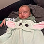 baby, blanket, child, comfort, couch, cozy, cushion, cute, face, green, indoors, person, pink, plush, relaxation, rest, sleeping, soft_texture, wrapped, young_child