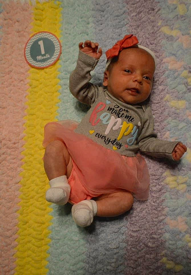 Evelyn is registered to the contest to win money with this photo: arm, baby, baby_products, baby_toddler_clothing, cheek, child, comfort, finger, flooring, foot, fun, happy, leg, linens, orange, person, play, room, sitting, toddler