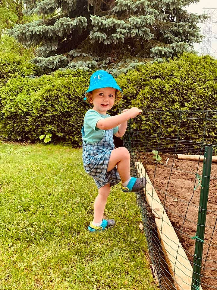 Sullivan is registered to the contest to win money with this photo: baby, baby_toddler_clothing, baseball_cap, cap, electric_blue, grass, grass_family, grassland, happy, hat, headwear, joy, landscape, lawn, leisure, people_in_nature, person, plant, recreation, shorts