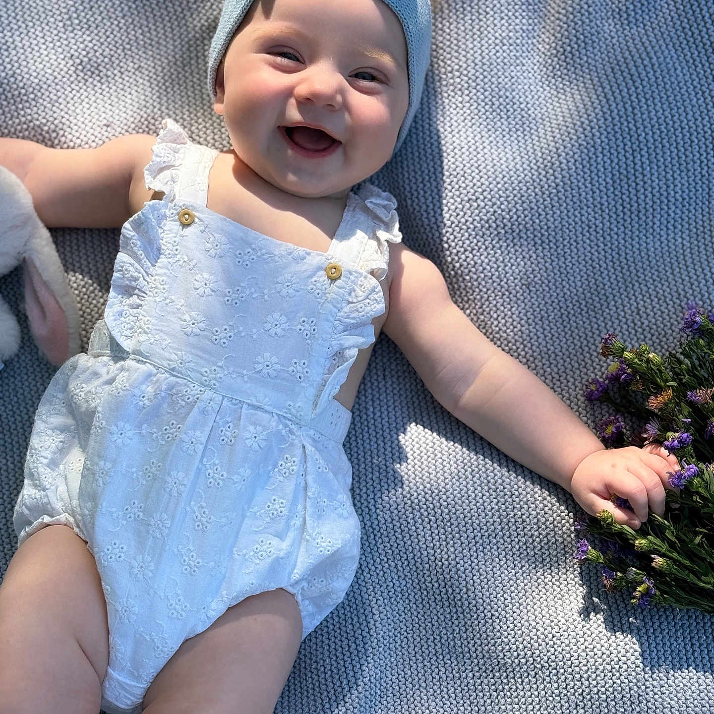 Vira joined the competition — help win amazing prizes! baby, blanket, bow, child, cute, flowers, happy, headband, infant, nature, outdoor, portrait, purple_flowers, romper, shadow, smiling, soft_light, sunlight, texture, white_clothing