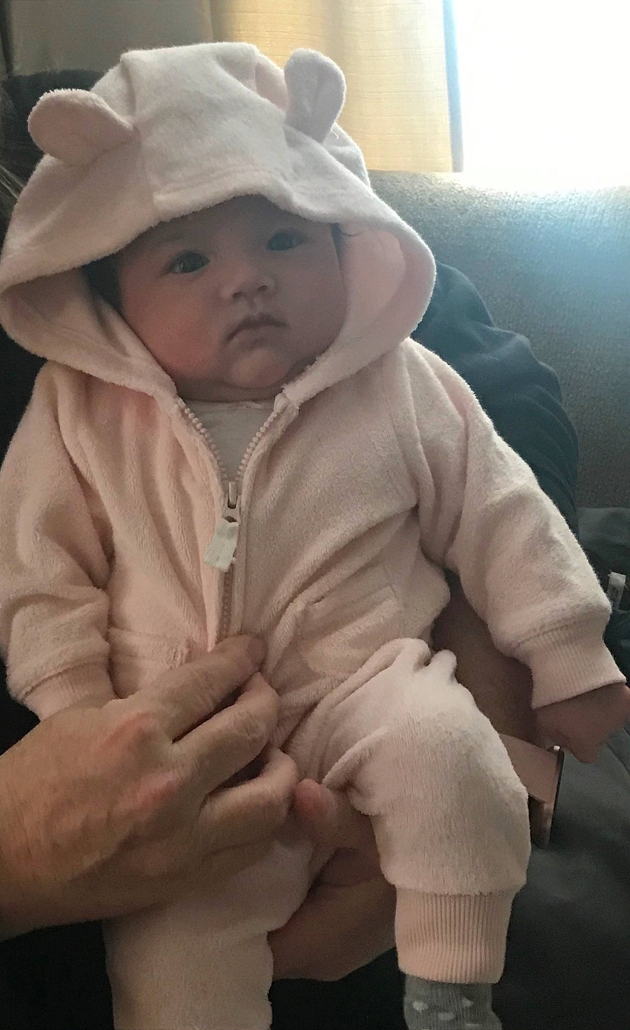 Stella joined the competition — help win amazing prizes! baby, baby_toddler_clothing, cap, cheek, comfort, finger, fur, gesture, hand, happy, headgear, headwear, jacket, lip, nose, outerwear, person, sitting, sleeve, smile