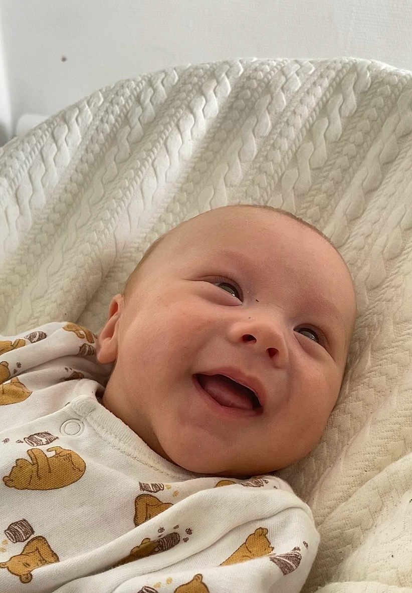 Léon participe au concours pour gagner de l'argent avec cette photo : baby, smiling, infant, blanket, onesie, bear_prints, happy, face, head, clothing, cozy, cute, portrait, child, young, soft_texture, indoors, lying_down, fabric, warm