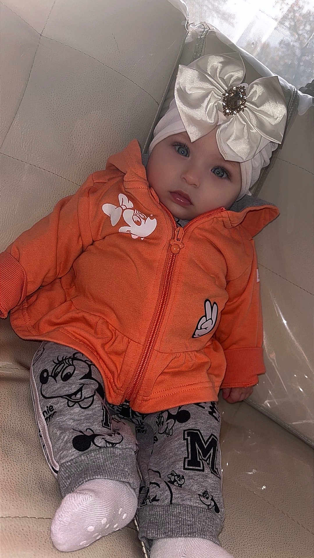 Evenly participe au concours pour gagner de l'argent avec cette photo : baby, child, hoodie, orange_clothing, gray_pants, cartoon_prints, headband, bow, gem, blue_eyes, leather_couch, sitting, indoor, cute, infant, sock, fashion, portrait, young_child, cozy