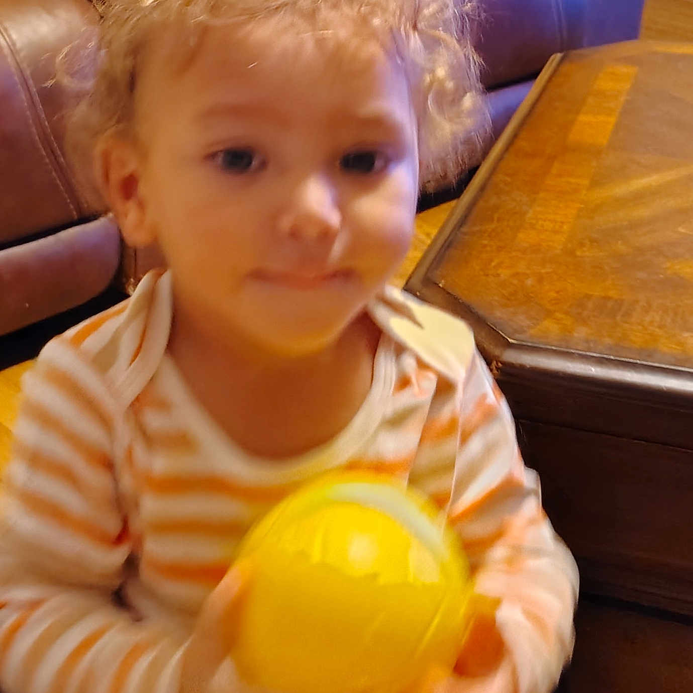 Jyaire Strickland joined the competition — help win amazing prizes! blurry, casual, cat_paws, child, curly_hair, cute, floor, furniture, home, indoor, leather_couch, person, playing, small_hands, smiling, striped_shirt, toddler, wooden_table, yellow_ball, young_child