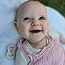 baby, smiling, blue_eyes, pink_clothing, knitted, infant, happy, closeup, face, outdoor, blanket, cute, portrait, child, toddler, soft_texture, skin, person, natural_light, background_blur