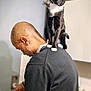 Chaussette a rejoint le concours — aidez-le/la à gagner de superbes lots ! cat, tuxedo_cat, man, shoulder, kitchen, cooking, stove, pot, black_sweater, bald_head, whiskers, indoor, appliance, countertop, focus, curious, pet, domestic_animal, white_paws, human