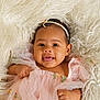 Aspyn is registered to the contest to win money with this photo: baby, infant, portrait, smile, headband, pink_dress, tulle, fur_blanket, blanket, soft_texture, cute, chubby_cheeks, big_eyes, hand, skin, studio_shot, adorable, closeup, laying_down, soft_lighting