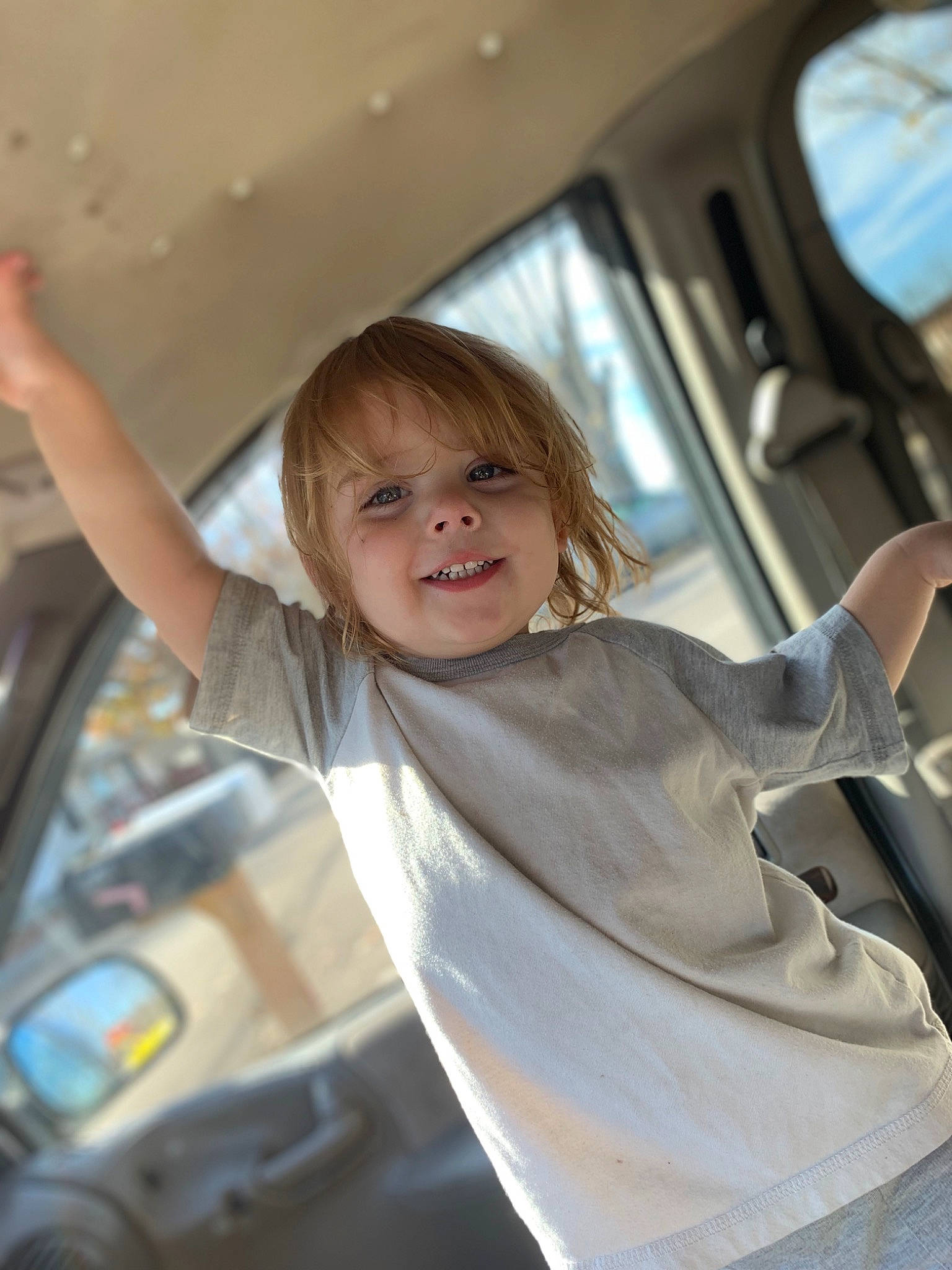 Gabe is registered to the contest to win money with this photo: arm, blond, child, dress, finger, flash_photography, fun, gesture, happy, joy, leisure, long_hair, person, shoulder, skin, smile, steering_wheel, toddler, vehicle_door, white