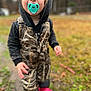 toddler, child, pacifier, outdoor, camouflage, hoodie, boots, grass, muddy, nature, person, young_child, clothing, autumn, portrait, curious, standing, daylight, face, cute