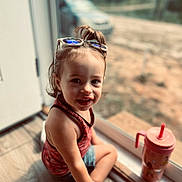 Huntley Grace joined the competition — help win amazing prizes! toddler, child, smiling, sunglasses, hair_top_knot, tank_top, shorts, sippy_cup, indoor, window, floor, natural_light, face, hand, footwear, person, young_child, casual_clothing, happy, seated