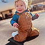 toddler, child, smile, outdoor, trampoline, hat, overalls, denim, happy, sunlight, shadow, play, casual_clothing, park, nature, daytime, cute, baby, portrait, warm_clothing