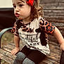child, girl, red_bow, leopard_print, shirt, leggings, bench, wood, outdoor, cute, face, expression, sitting, fashion, portrait, hair, casual, young, playful, daylight