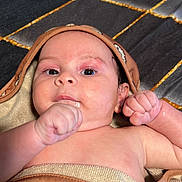 Sandiel joined the competition — help win amazing prizes! baby, infant, towel, wrapped, hood, fist, curious, relaxed, skin, lying_down, indoors, texture, pattern, face, closeup, child, newborn, cute, portrait, person