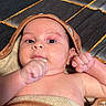 baby, infant, towel, wrapped, hood, fist, curious, relaxed, skin, lying_down, indoors, texture, pattern, face, closeup, child, newborn, cute, portrait, person